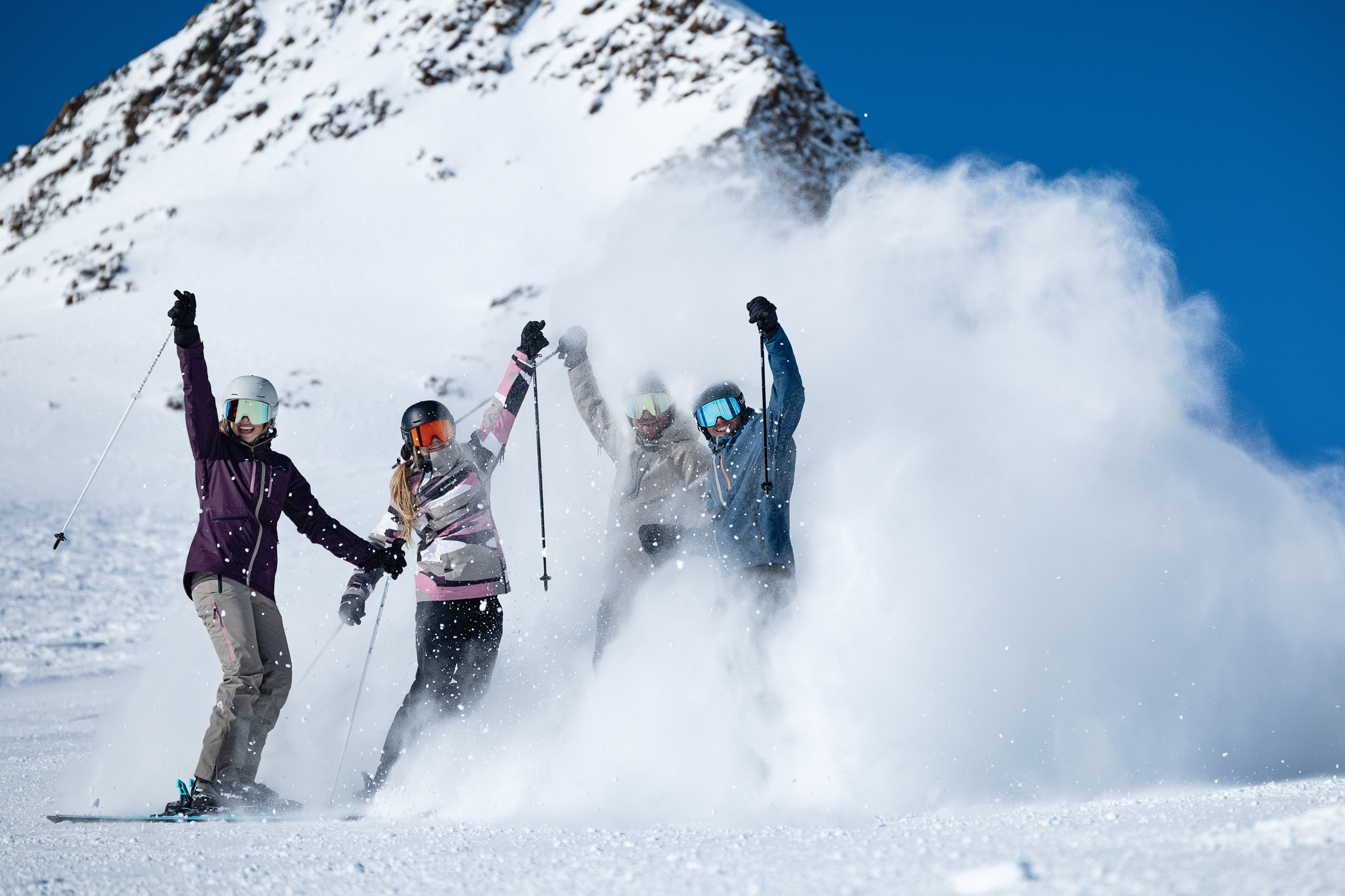 Gruppe von Skifahrern feiert auf verschneiter Bergpiste, Winter-Skiurlaub.
