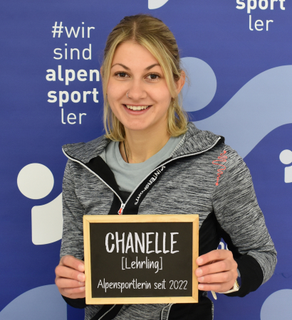 Chanelle, Alpensport athlete, holding sign with name; Alpen sports promotion, ski and outdoor sports.