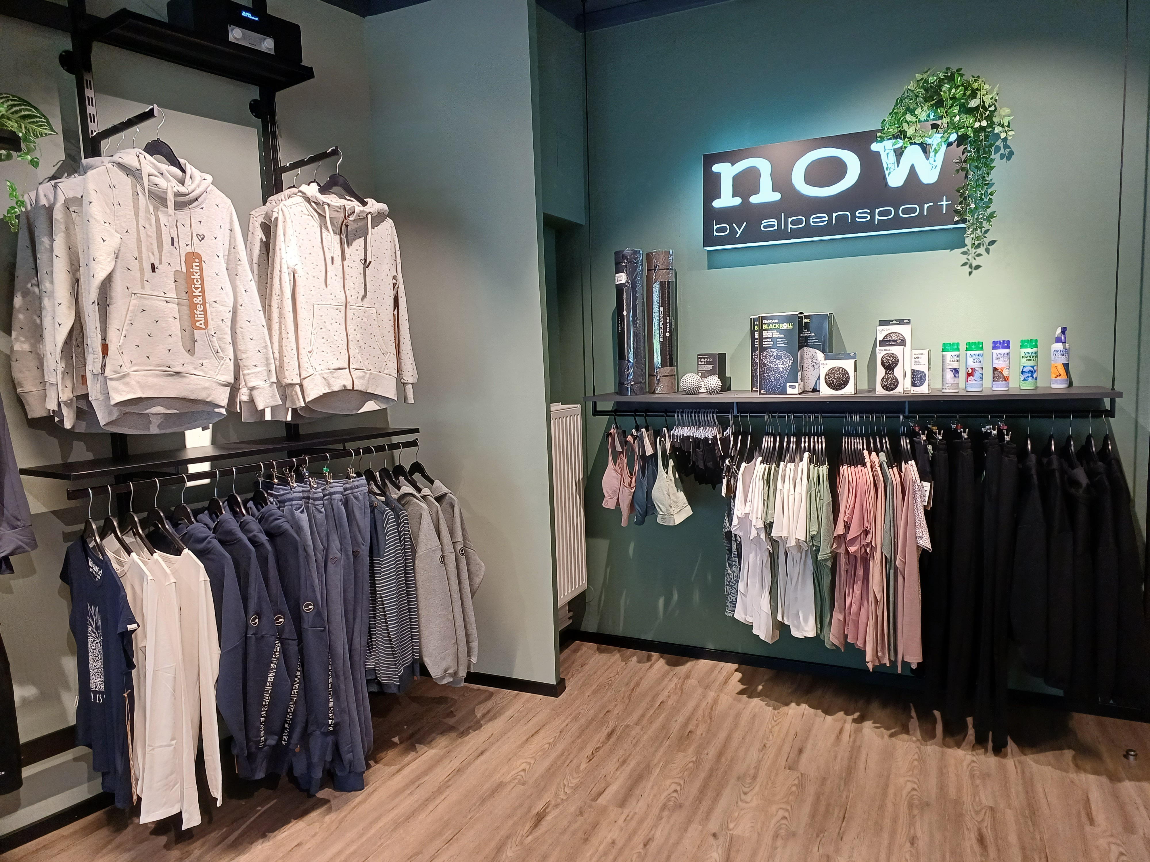 Innenausstattung eines Bekleidungsgeschäfts: Hoodies, Jeans und Bekleidung in einer modernen Modeboutique.